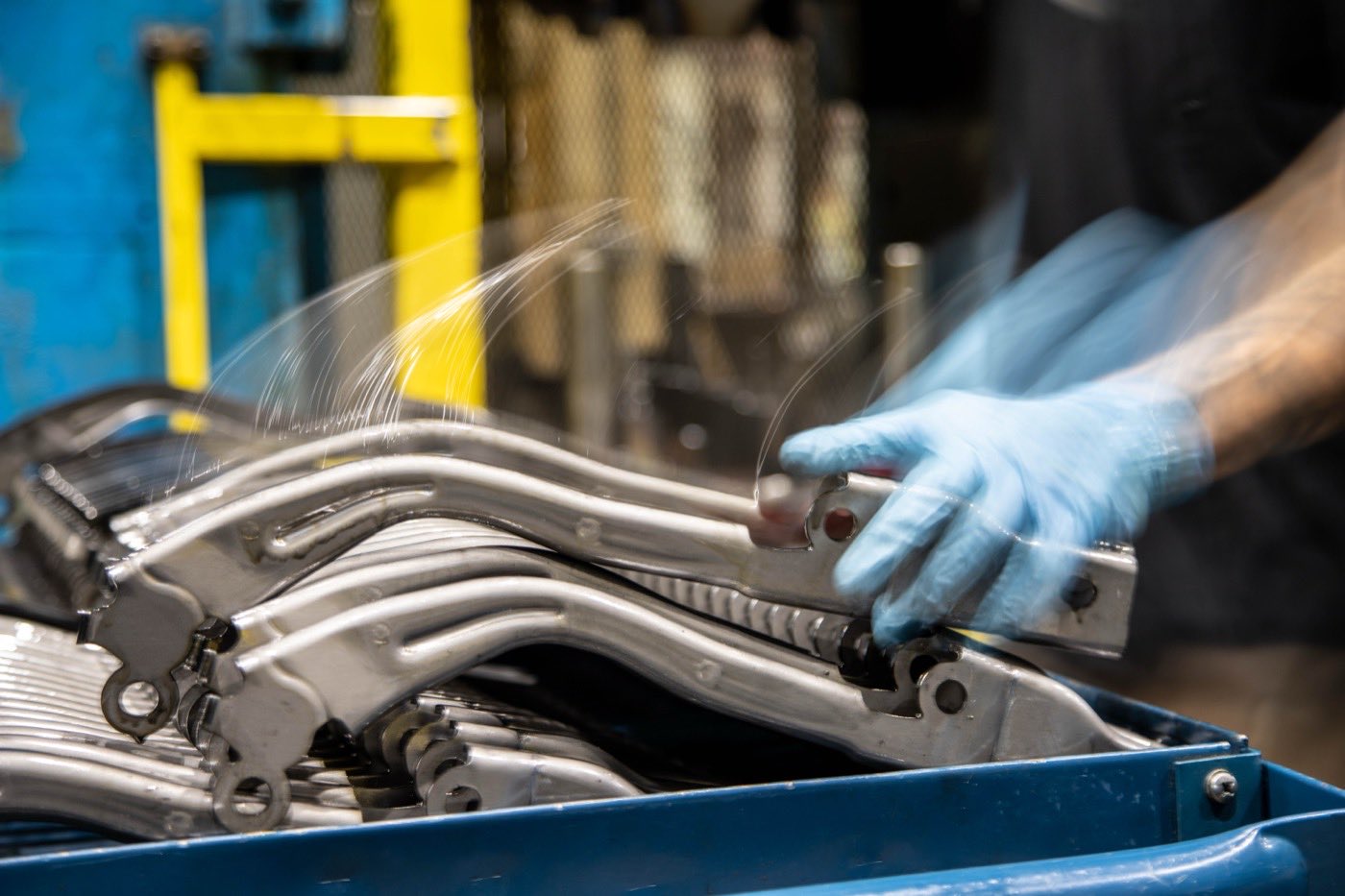 A Prototier-1 operator stacking formed production parts at the press