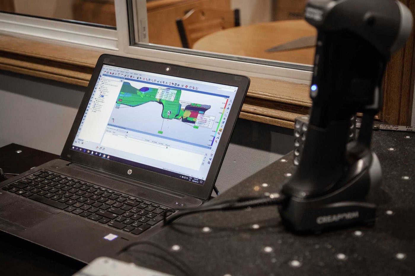 A Creaform 3D scanner beside a laptop showing a colour deviation heat map at Prototier-1